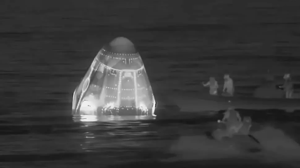 El equipo de rescate se aproxima a la nave Dragon para llevarla al barco de rescate y posteriormente a tierra.