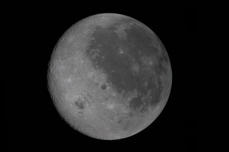 En esta vista de la Luna completamente iluminada, el lado cercano (el hemisferio que vemos desde la Tierra) aparece a la derecha. Se reconoce por las manchas oscuras que cubren su superficie, que son antiguos flujos de lava de una época temprana en la historia lunar, cuando el satélite tenía actividad volcánica. El gran cráter situado al oeste de estas llanuras de lava es la cuenca Orientale, un enorme cráter de casi 965 km de diámetro que se extiende entre el lado cercano y el lado oculto de la Luna. Desde la Tierra no podemos ver su mitad izquierda, pero en esta imagen se observa completo. Todo lo que aparece a la izquierda del cráter corresponde al lado oculto, el hemisferio que no podemos ver desde la Tierra, ya que la Luna gira sobre su eje a la misma velocidad a la que orbita nuestro planeta. Credit: NASA