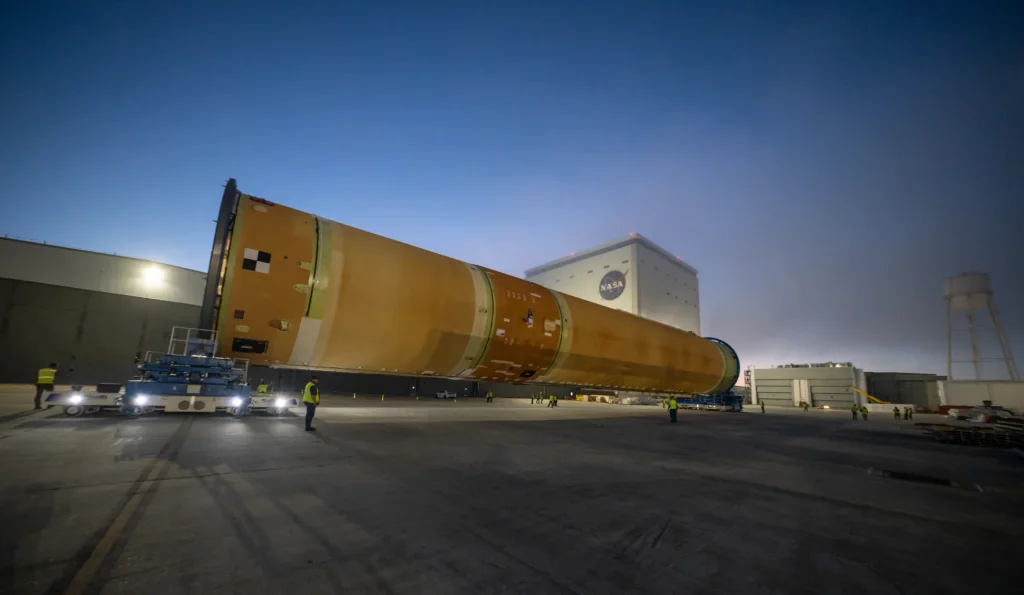 En la imagen se muestra la parte superior —equivalente a cuatro quintas partes— de la etapa central del SLS, que incluye el tanque de hidrógeno líquido, el tanque de oxígeno líquido, la sección intermedia y la estructura frontal. La NASA trasladará esta sección, la más grande del cohete destinado a la misión tripulada Artemis III, desde las instalaciones de ensamblaje Michoud el lunes 20 de abril hasta el Centro Espacial Kennedy, en Florida. Credit: NASA