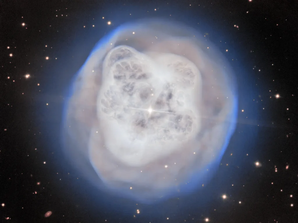 El telescopio Gemini Norte, de 8,1 metros y ubicado en la cima del Maunakea, en Hawai‘i, captó a NGC 1514, más conocida como la Nebulosa Bola de Cristal, con un nivel de detalle impresionante. Esta nebulosa, envuelta en un fascinante resplandor gaseoso, guarda pistas de una muerte estelar pasada, mientras que su envoltura asimétrica sigue siendo moldeada por el sistema binario situado en su centro. Créditos: International Gemini Observatory/NOIRLab/NSF/AURA