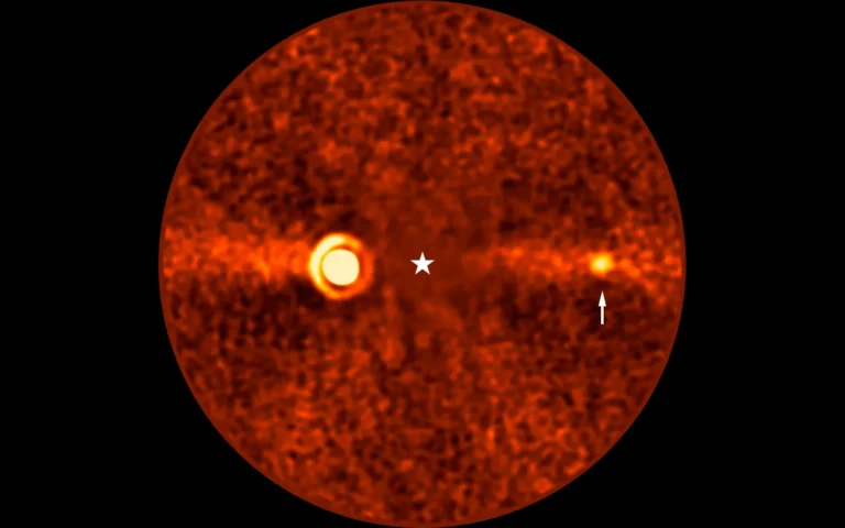 Esta imagen, obtenida con el Very Large Telescope (VLT) de ESO, muestra a Beta Pictoris d, un nuevo planeta que orbita la estrella Beta Pictoris. La estrella está en el centro de la imagen y se restó su brillo al procesar los datos, revelando el entorno que la rodea. El nuevo planeta, indicado con una flecha, es el tercero que se encuentra alrededor de esta estrella. Los otros dos son Beta Pictoris b (la fuente brillante a la izquierda), y Beta Pictoris c, orbitando mucho más cerca de la estrella y que en esta imagen no se ve.